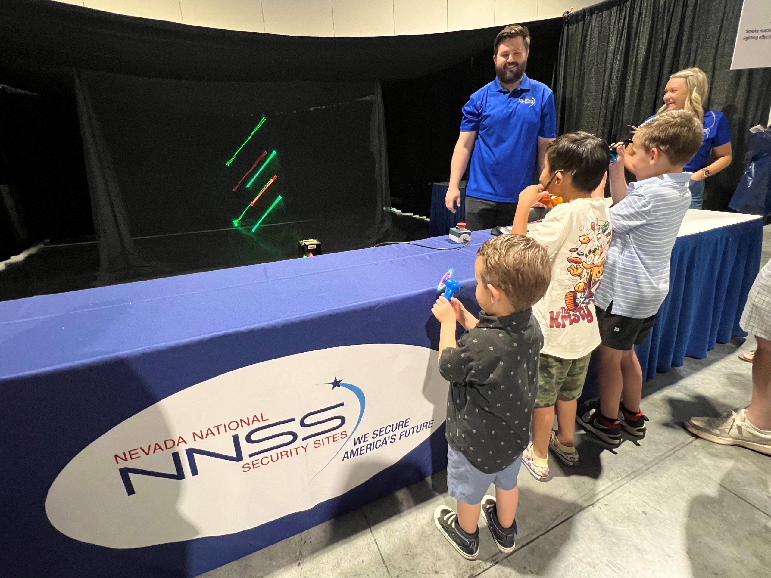 Three students watch lasers in motion.