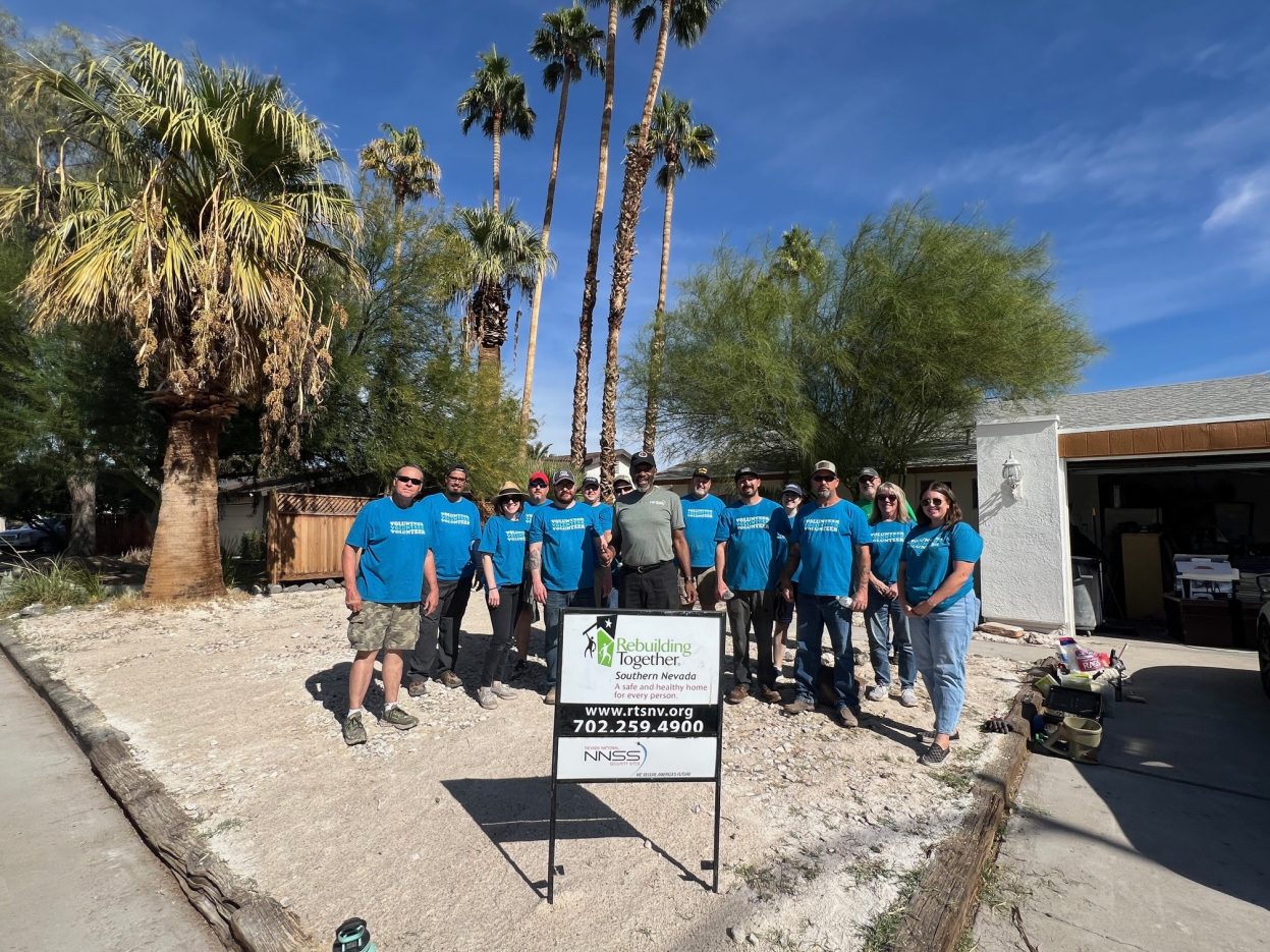 NNSS volunteers stand with a homeowner at his property.