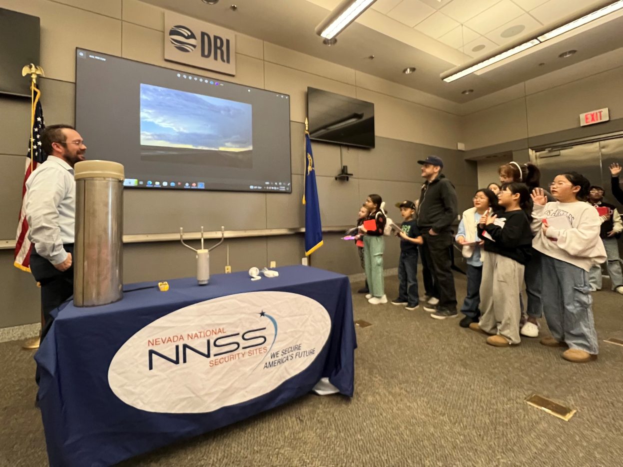 A meteorologist shows a video of a storm to students.