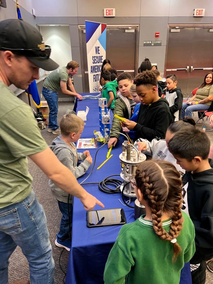 A NNSS employee demonstrates geology concepts to students.