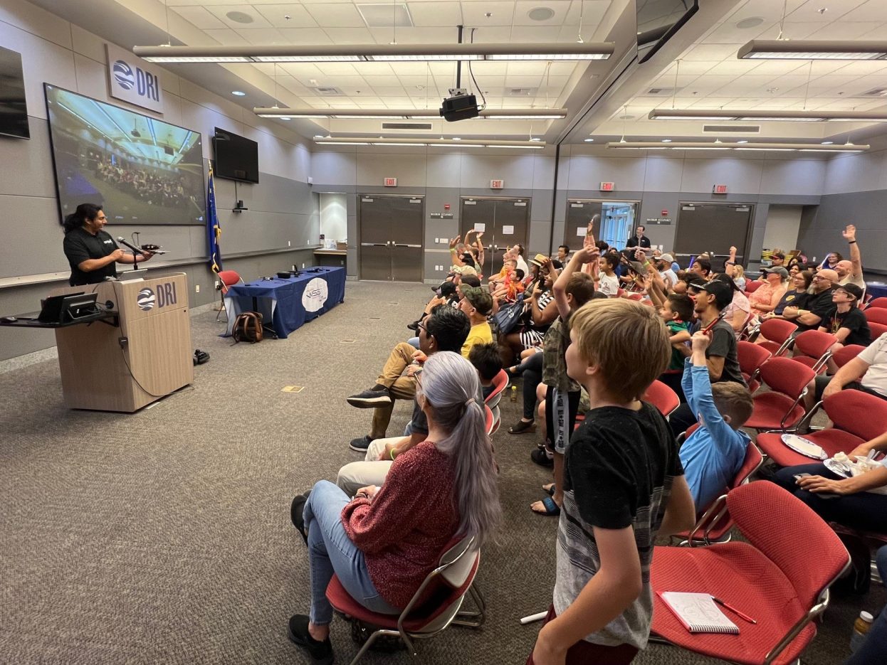 Students and parents watch an autonomous system operate inside a meeting room.