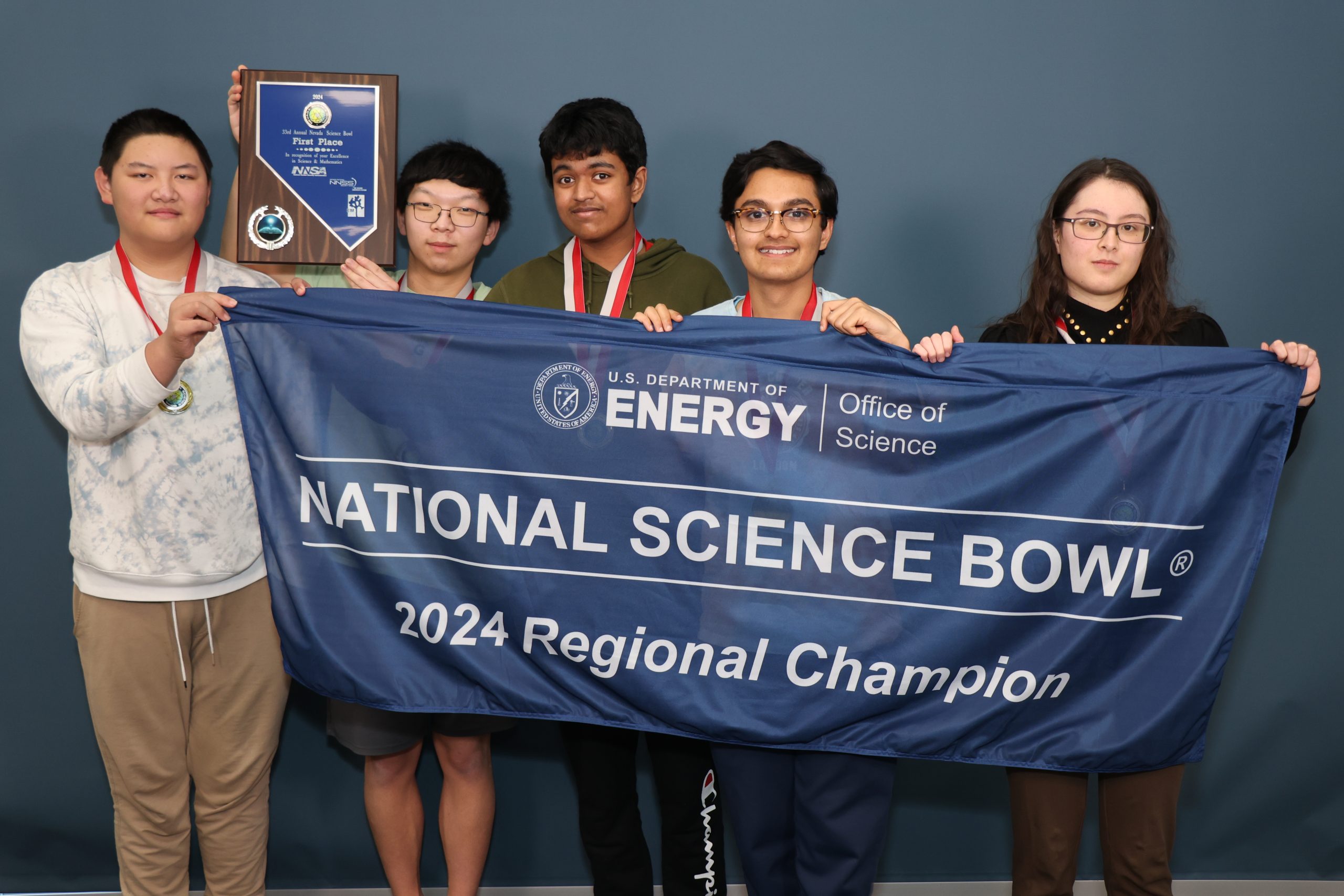 Five students hold a navy blue banner that reads "2024 Regional Champion."