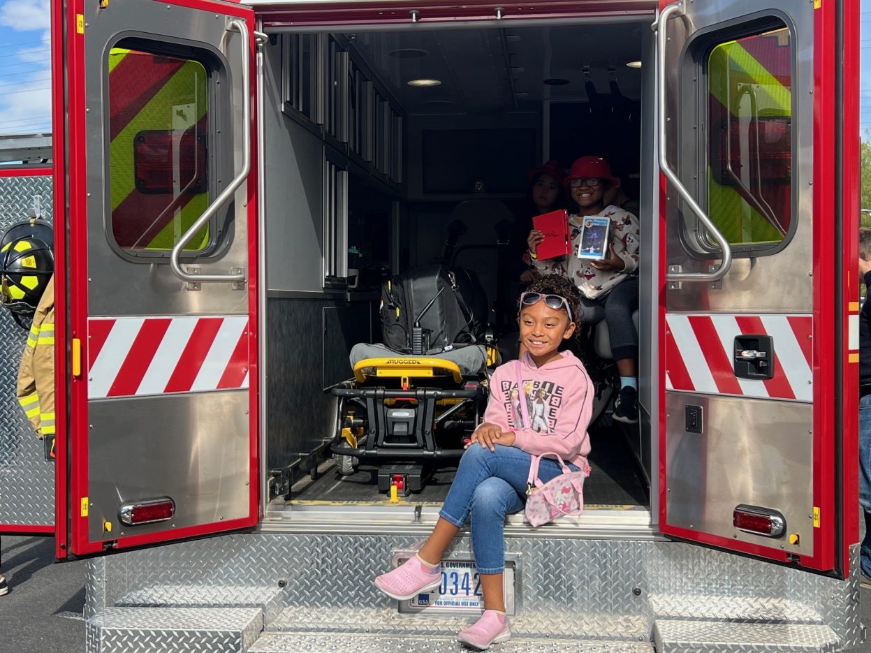 A student sits inside an EMS vehicle.