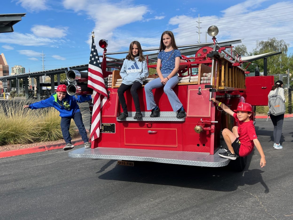 Four students sit on the Seagrave fire truck. 