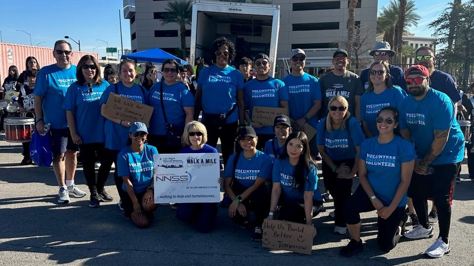 NNSS volunteers in blue t-shirts smile.