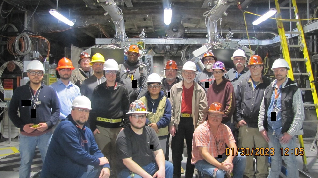 group of men and women in hard hats in front of Cygnus machine