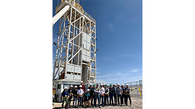 group of employees in hard hats in front of hoist at U1a Complex