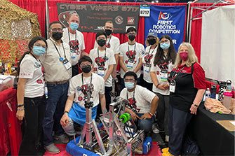 High school robotics team posing with their robot and MSTS President Mark Martinez