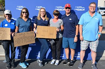 Navarro employees hold signs and pose for a photo at a recent charity walk event