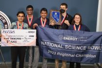 five students holding big fake check, plaque and banner for winning Nevada Science Bowl