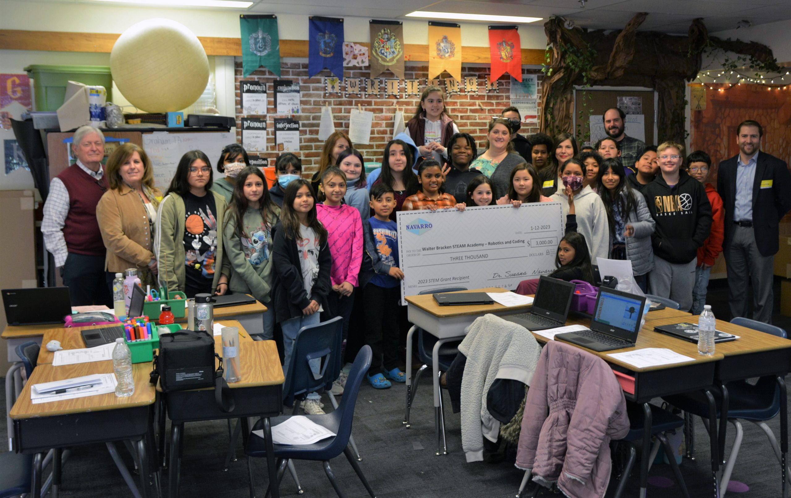 group of children and adults holding big check in a classroom