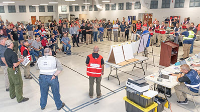 large room with multiple people getting an exercise briefing