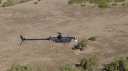black drone in flight over desert
