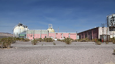 pink building with white tank to left and another building to right