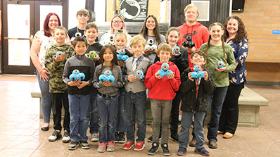 group of students hold mini robots