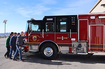 NNSS officials symbolically push the new fire engine into the station