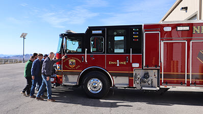 NNSS officials symbolically push the new fire engine into the station