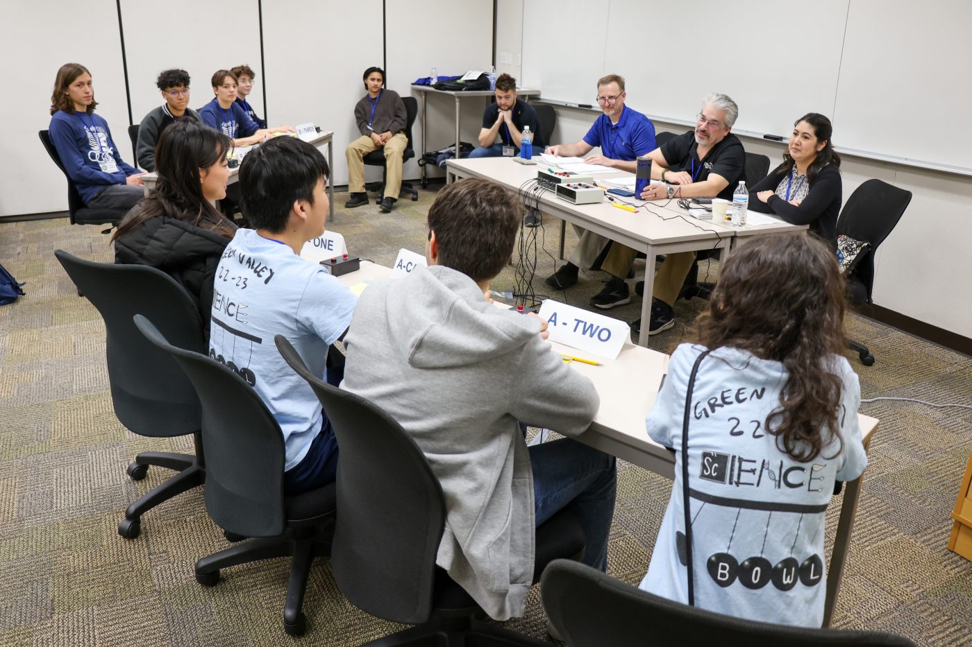 room with students and adults sitting at tables for Nevada Science Bowl competition