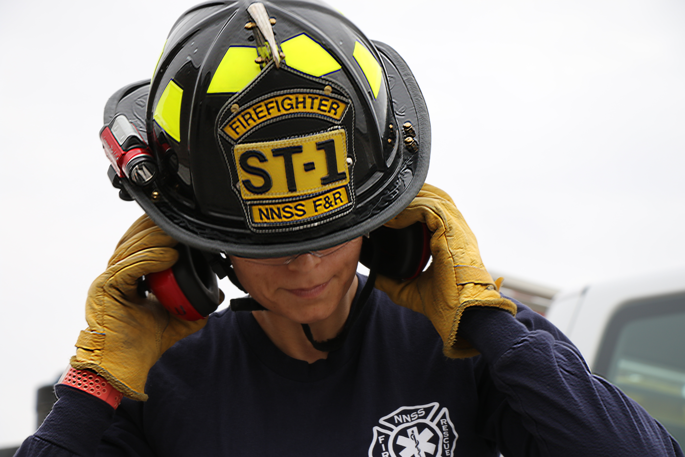 female firefighter holding her ear protection