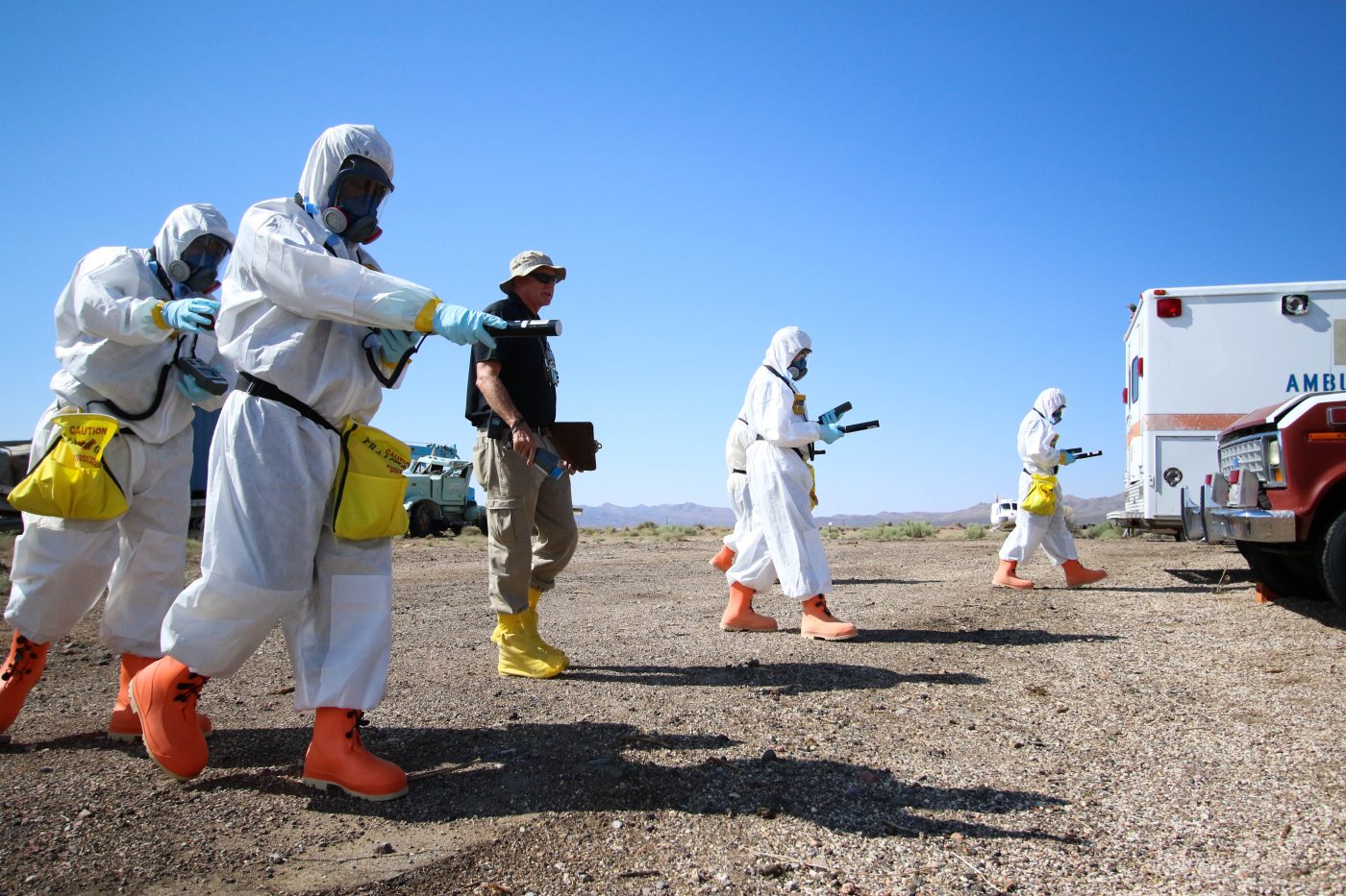 A Counter Terrorism Operations Support leader coaches trainees wearing personal protective equipment at the NNSS T-1 training site.