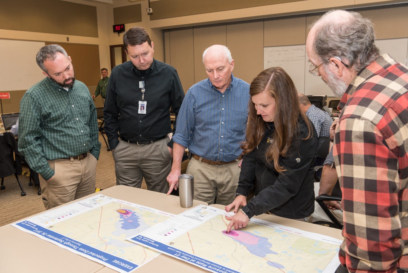 Five RSL team members consult a map for planning.
