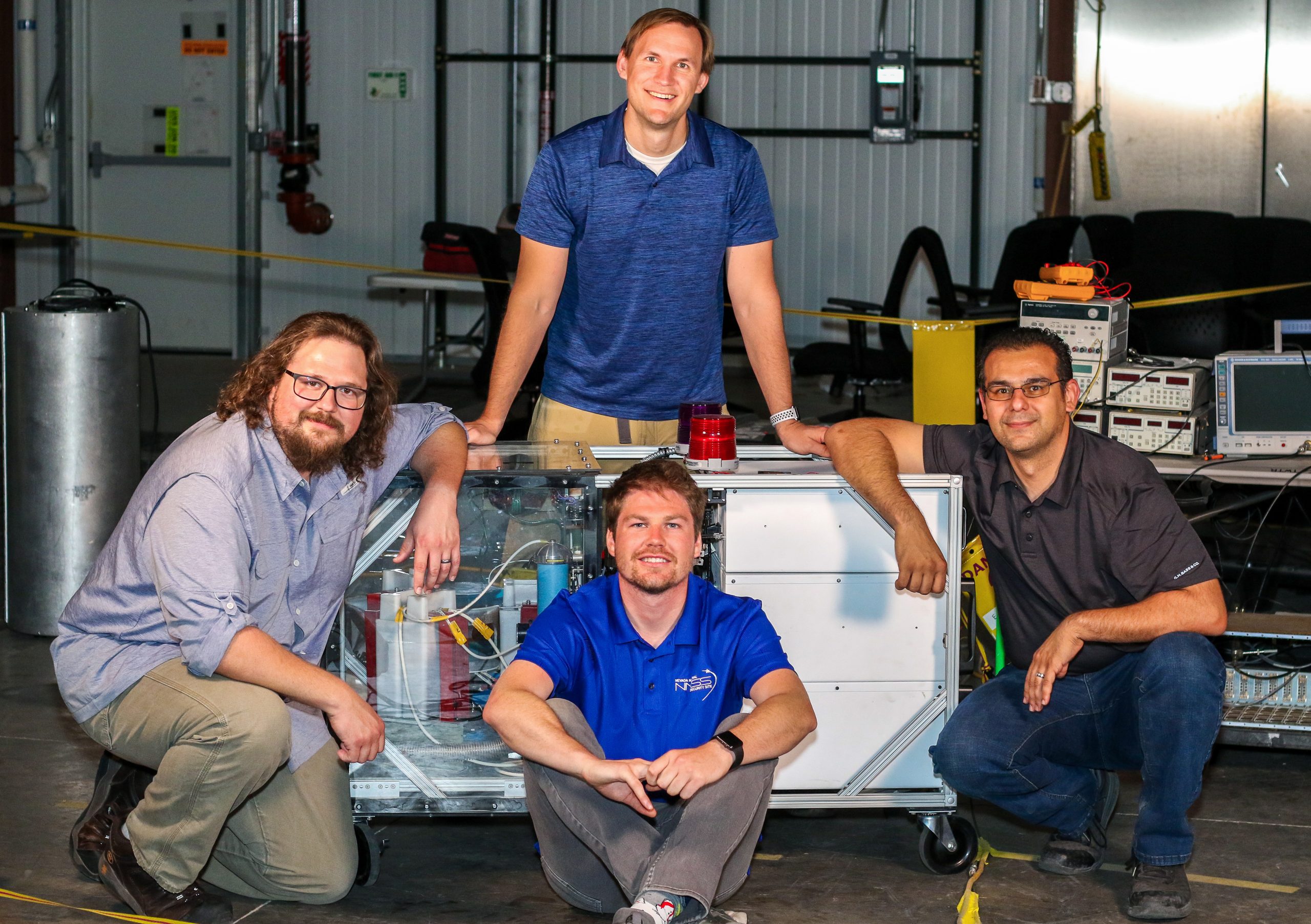 four men around portable DPF machine that was a R&D 100 award finalist and SDRD project