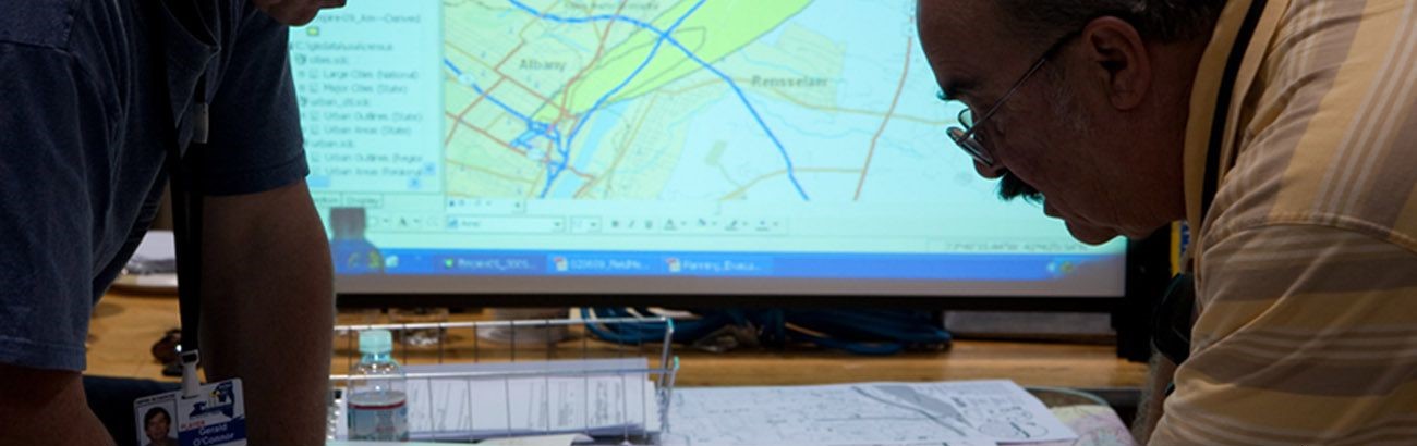 A man reviews maps on a drafting table.