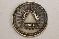 gold coin with triangle in middle with LLNL, NNSS and NNSA down sides and United States Department of Energy below the triangle