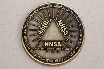 gold coin with triangle in middle with LLNL, NNSS and NNSA down sides and United States Department of Energy below the triangle