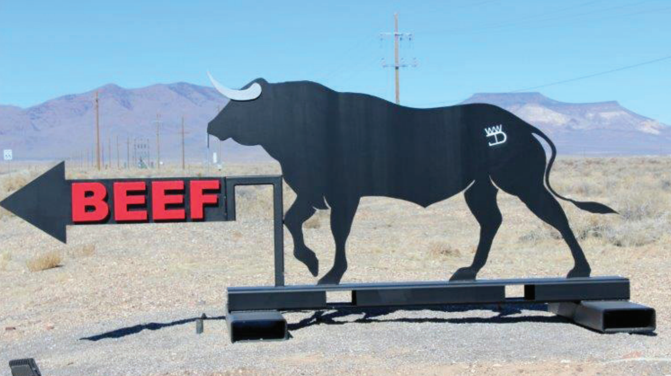 A sign depicts a bull walking toward the direction of the BEEF testing facility.
