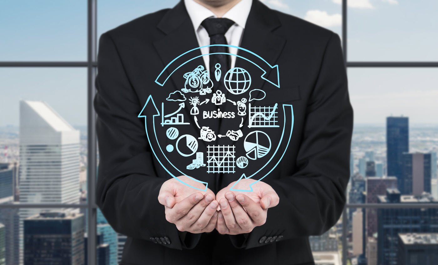 man in black suit holding out hands with business icons floating above them and window with skyline in the background