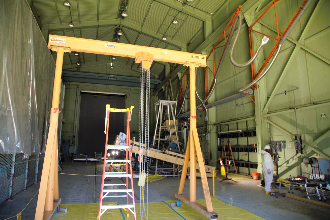 view inside a yellowish building with yellow equipment and ladders