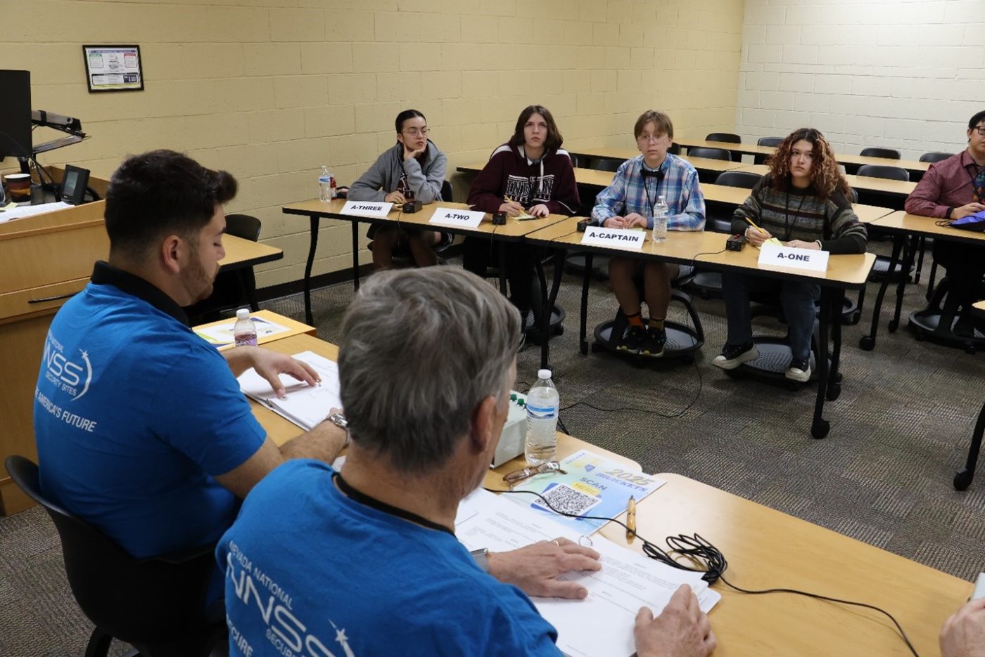 Judges read Nevada Science Bowl questions to students inside a classroom. 