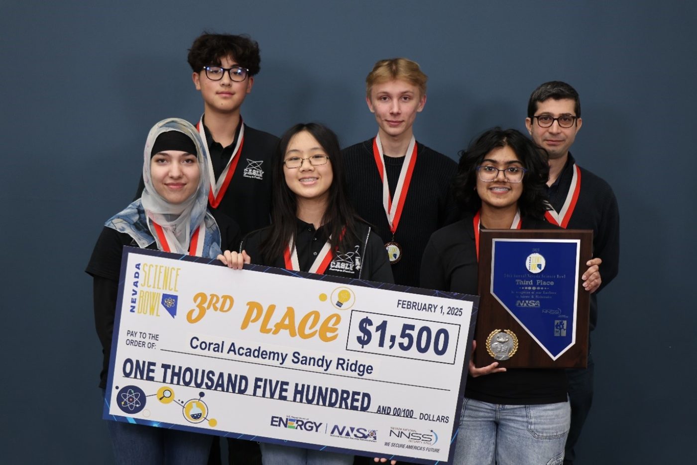 Students hold an oversized check marked $1,500.