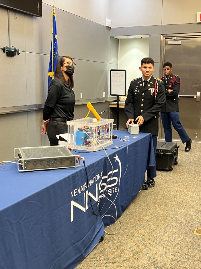 A student approaches a science demonstration.