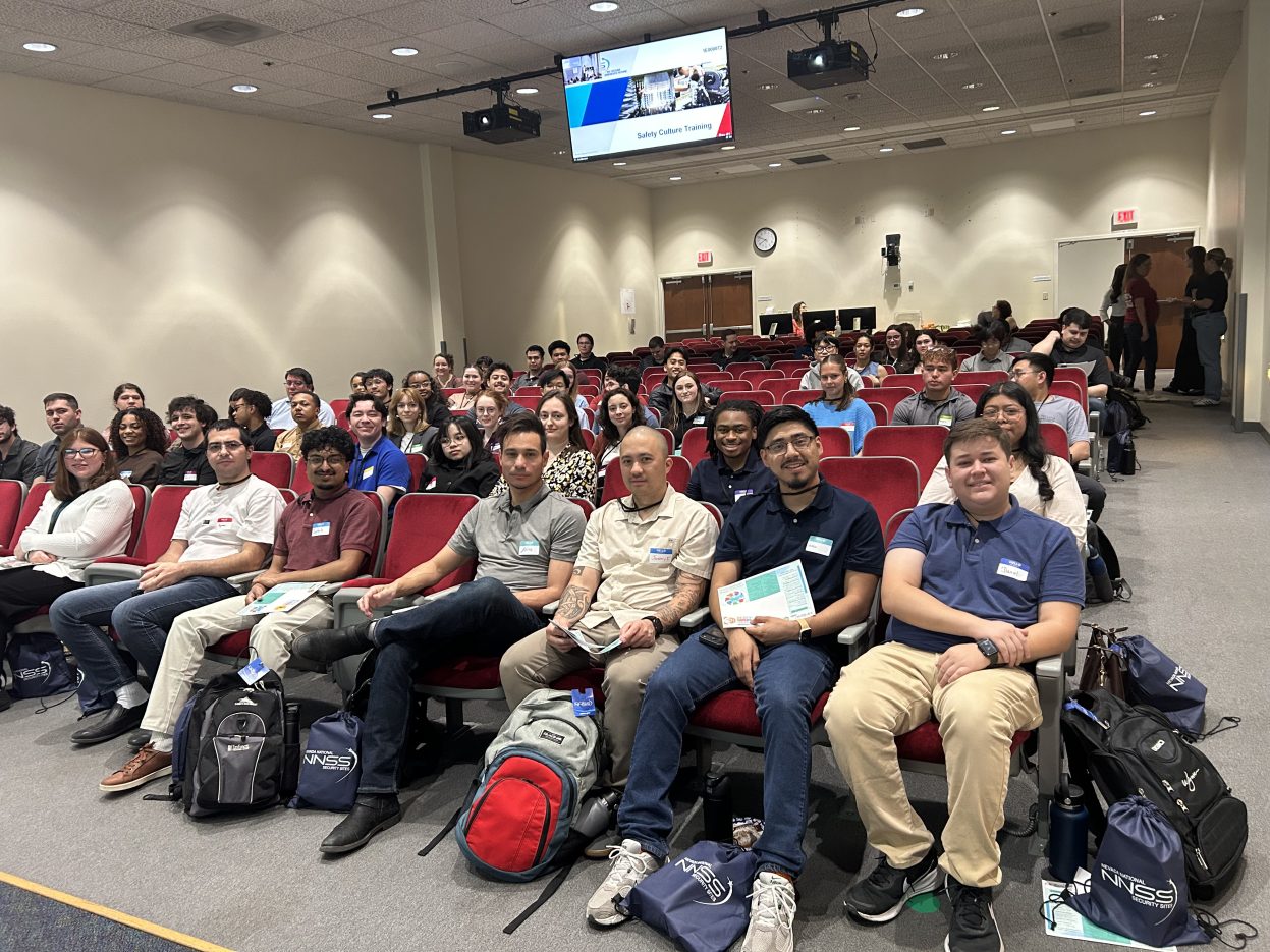 group photo of students sitting in chairs in an auditorium