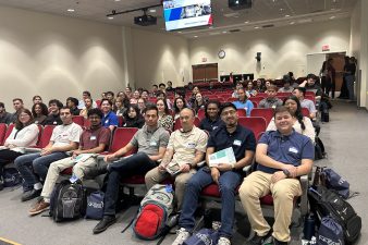 group photo of students sitting in chairs in an auditorium