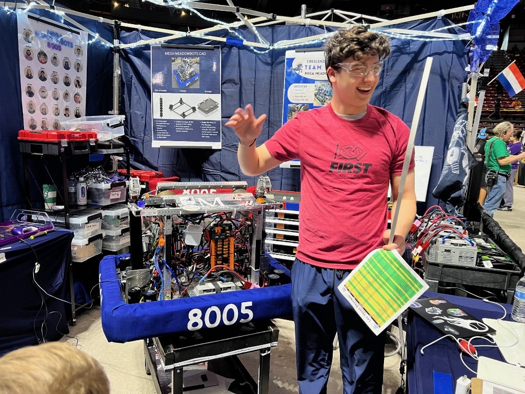 A student demonstrates features of robot inside a booth.