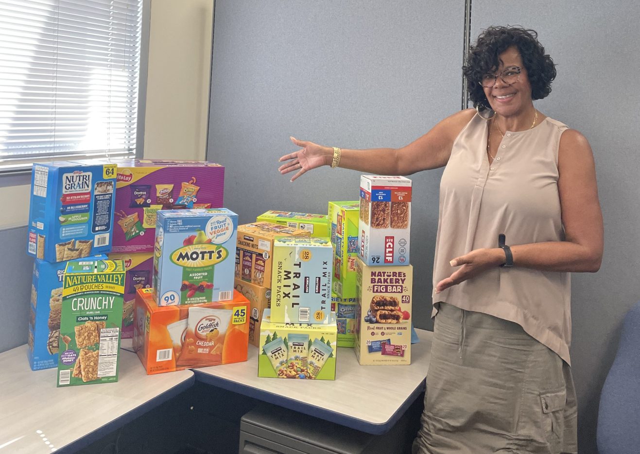 A NNSS employee stands with boxes of food donations.