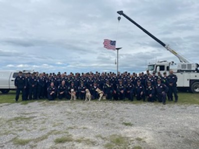 Nevada Task Force 1 and K-9s stand in front of the American flag.