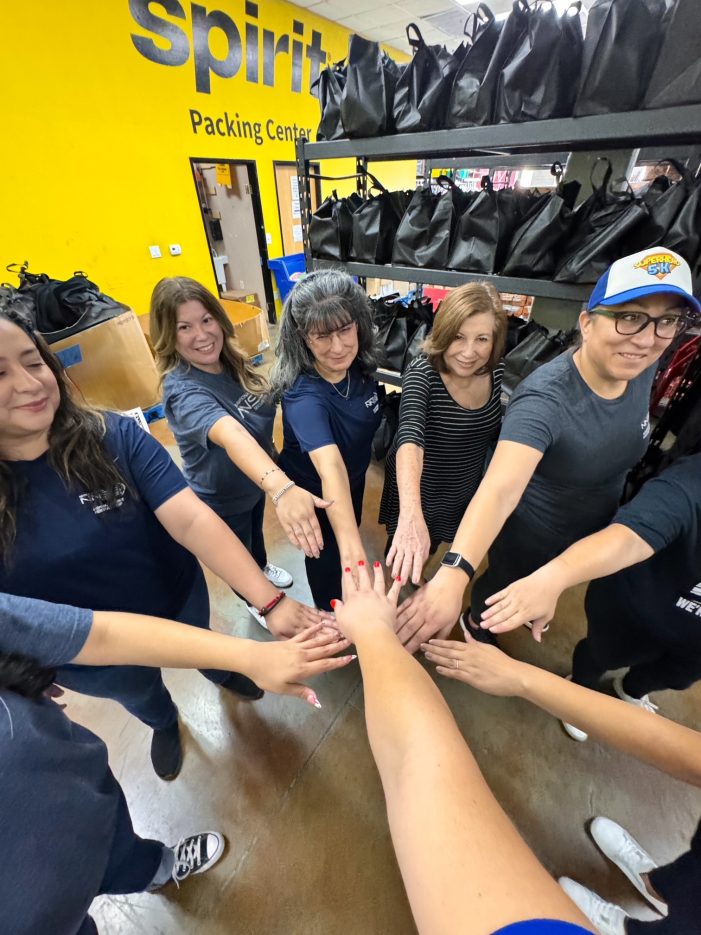 group of volunteers putting their hands together