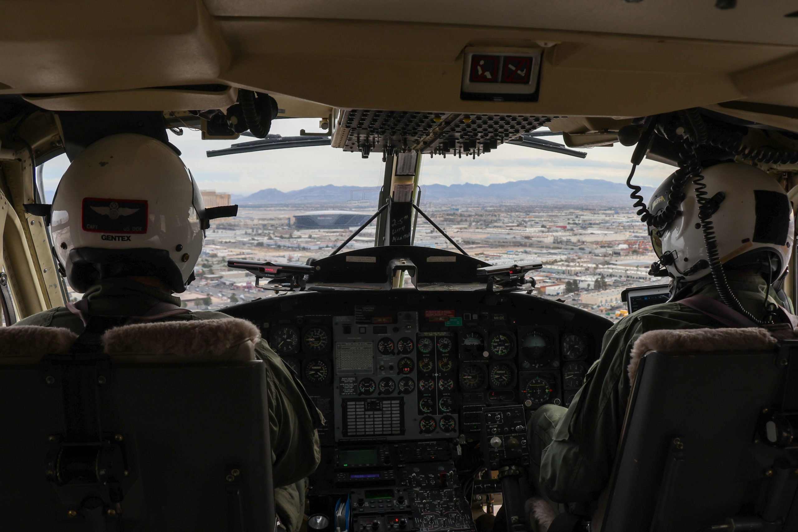 Two pilots in a helicopter fly over the city of Las Vegas.