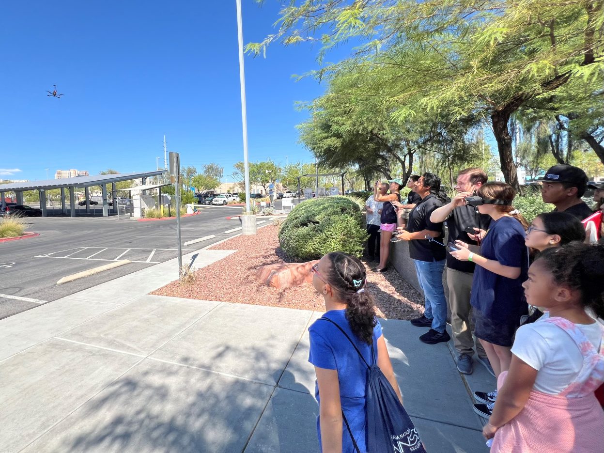 A student operates a drone while wearing a virtual reality headset. 