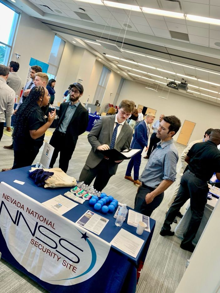 students talking with employees at a career fair