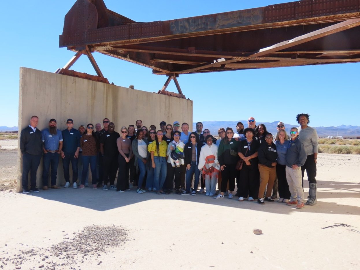 group of 20+ people standing at a historical stop on the Site tour